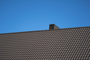 Brown corrugated metal profile roof installed on a modern house. The roof of corrugated sheet....