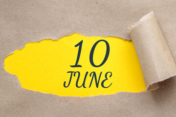 june 10. 10th day of the month, calendar date.Hole in paper with edges torn off. Yellow background is visible through ragged hole.Summer month, day of the year concept