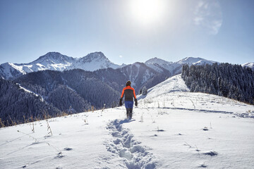 Man is walking in winter mountains
