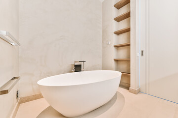 Minimalist bathroom interior design with big soaking tub in center and empty shelves built in wall