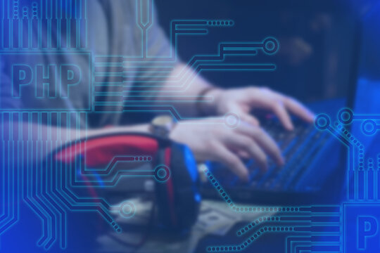 PHP logo. Programmer near computer. Man works next to a laptop. Website development using PHP. Hands on keyboard. Website development. Programmer writes PHP code for website. Hypertext Preprocessor