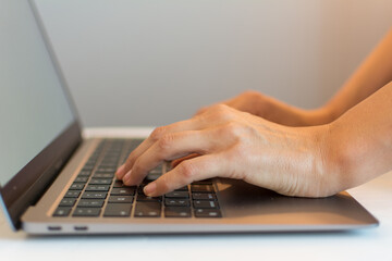 Close up of female hands working on a laptop with selective focus