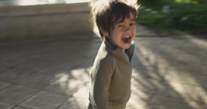 Smiling boy running outdoors, Acre, Israel