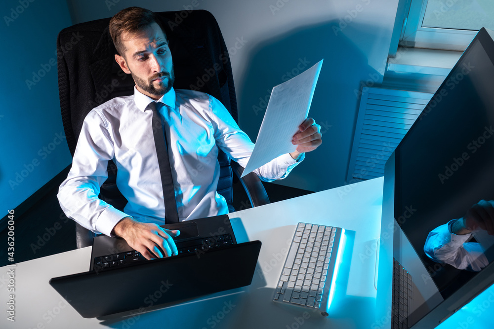 Poster overtime work. man works in a dark office. concept - he has to work overtime. office worker prints a