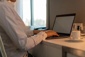 Young female working at a desk at home on a laptop. Concept of Homeworking