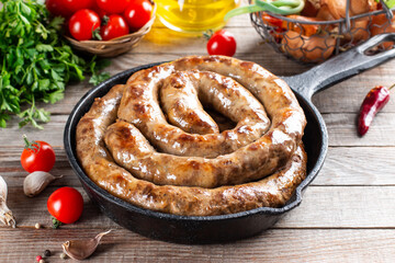 Baked homemade sausage with spices and herbs, close up. Spiral grilled homemade sausage.