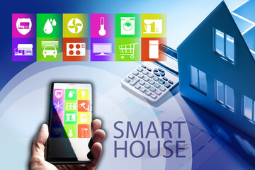 Smart house technology. Smart house technology application in phone. Concept - smart house system design. IOT control hand next to designer's table. Integration of IOT systems during construction.