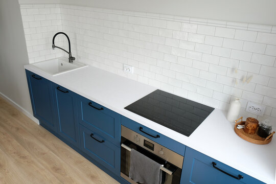 Modern kitchen interior design. Nordic style blue cabinets and white countertop top view.
