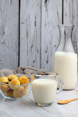 breakfast and snack with milk, chocolate and homemade breads with bottle and elegant glass and sugar on counter and wooden background