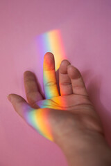 Rainbow on the woman's hand. Mystical moment. LGBT sign on the hand. Illustrative picture for LGBT support. 