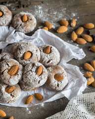 Fototapeta na wymiar Amaretti, traditional Italian cookies with almonds on baking paper on wooden background background. Selective focus