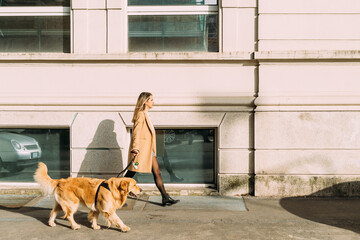 Woman with dog walking along street