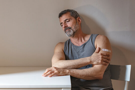 France, Man with bandage on arm sitting at table