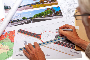 Plan, carte et photomontage d'un projet routier d'aménagement du territoire posés sur un bureau
