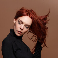 portrait of a red-haired woman on a beige background.