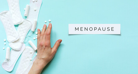 Women's health.Menopause word on blue background.Top view. Banner.