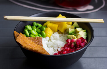 Asian dish and chopsticks. Green beans, white rice, avocado, pomegranate seeds
