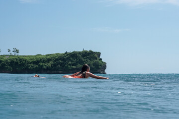 Young woman with beautiful body in swim suit surfer on surf board