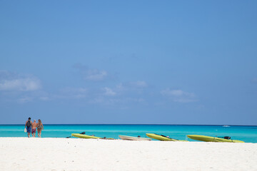 Kayaks on white sand against the backdrop of the turquoise sea. Canoe on the beach.