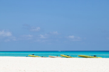 Kayaks on white sand against the backdrop of the turquoise sea. Canoe on the beach.