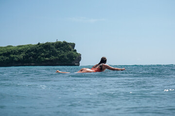 Young woman with beautiful body in swim suit surfer on surf board