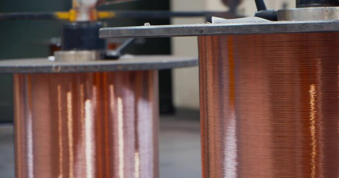 Unwinding of two bright copper coil at a cable factory, close up