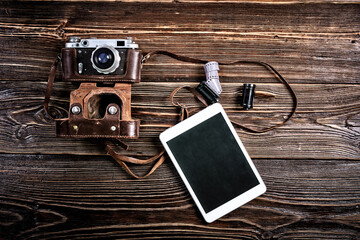 Close-Up Of Vintage Camera with films and pen tablet on old wooden table