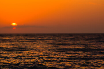 Amazing sea sunset on the pebble beach, the sun, waves, clouds