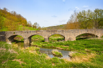 Fototapeta na wymiar Stone bridge at Tauberscheckenbach in spring, on the Tauber River, Bavaria, South Germany