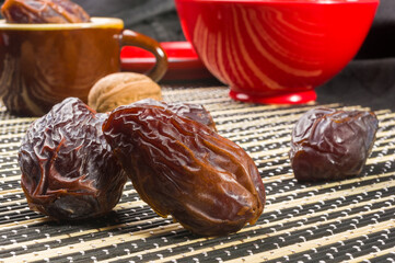 Big luxury dried date fruit on the bamboo mat, kurma ramadan kareem concept, close up.