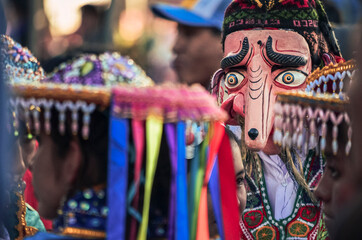 Traditional peruvian mask portrait within colorful dressed women during christian celebration of the saint San Antonio Abad. Festival and procession. January 17. 2014, Cusco, Peru, South America