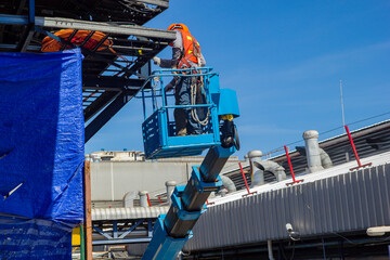 Two male industry working at high in a boom lift electrical © chitsanupong