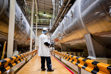 Male work inspection process milk powder cellar at the with horizontal stainless steel tanks