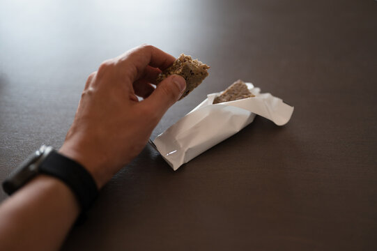 Man's Hand Holding Protein Bar Supplement