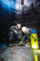 Male two worker inspection scan tank of rust thickness bottom plate