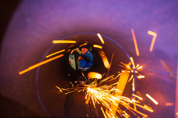 Male worker grinding repair or inside pipe sparks industrial