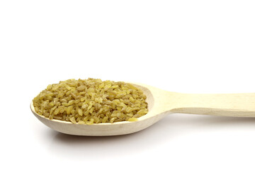 bulgur wheat grain in a wooden spoon isolated on a white background. Vegan healthy food