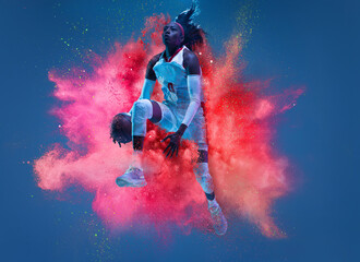 One young woman sportsman basketball player in explosion of colored neon powder isolated on dark...