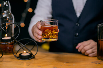 Waitress man standing pours whiskey into a glass celebrate whiskey on a friendly party in restaurant