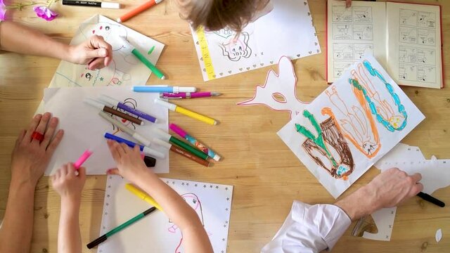 Top view kids playing drawing with coloured pencil at home