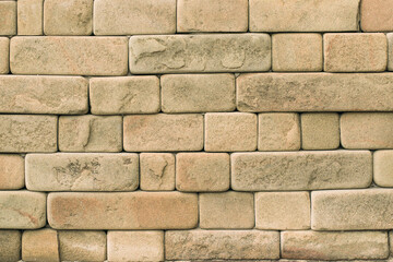 Shaggy, soft texture of geometric sandstone bricks wall background. Natural stone building...