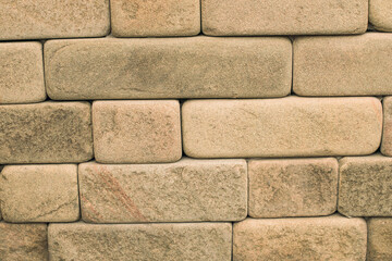 Shaggy, soft texture of geometric sandstone bricks wall closeup. Natural stone building materials background.