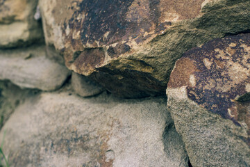 Rough wall of untooled stones side view with natural shaggy texture. Sandstone garden and nature background.