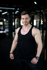 Handsome bodybuilder posing for camera. Fitness young male trainer.