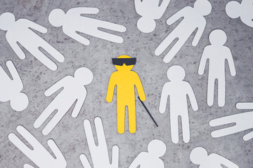Silhouette of blind disabled man with cane and glasses. yellow lone figure in middle of other...