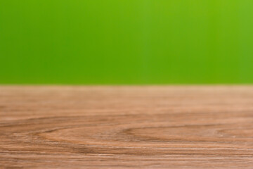 Background with wooden table and green bokeh.