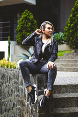 Vertical shot of a blonde Hispanic female sitting in a park
