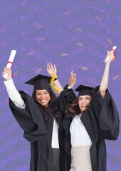 Composition of two happy diverse female students with certificates in graduation hats on purple