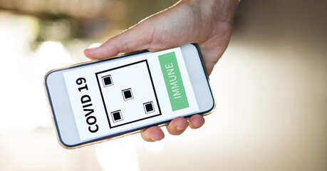 Composition of woman holding smartphone with covid 19 immune text