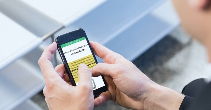 Composition of woman holding smartphone with covid 19 international certificate of vaccination